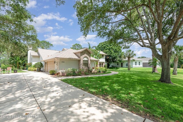 3750 Shady Run Rd, Melbourne, FL 32934 - view of front of house featuring stucco siding, a front yard, a garage, and driveway