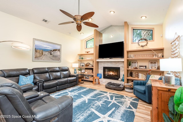 3750 Shady Run Rd, Melbourne, FL 32934 - living area with lofted ceiling, wood finished floors, a ceiling fan, and a glass covered fireplace