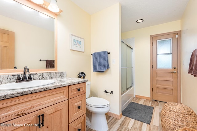 3750 Shady Run Rd, Melbourne, FL 32934 - full bathroom with wood finished floors, vanity, toilet, baseboards, and shower / bath combination with glass door