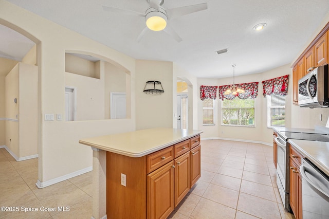 638 Brockton Way W, Melbourne, FL 32904 - kitchen with stainless steel appliances, light countertops, light tile patterned flooring, and brown cabinetry