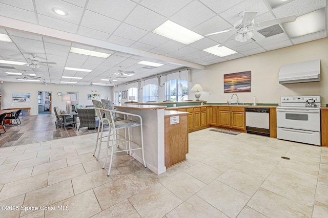 638 Brockton Way W, Melbourne, FL 32904 - kitchen featuring white appliances, ventilation hood, ceiling fan, a peninsula, and a paneled ceiling