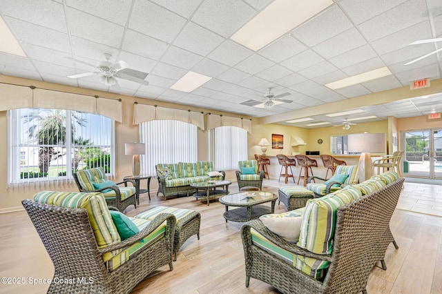 638 Brockton Way W, Melbourne, FL 32904 - living room featuring a ceiling fan, a drop ceiling, and light wood-type flooring