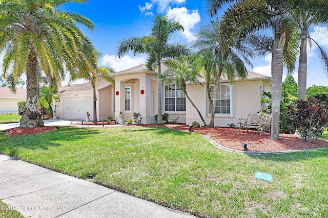 1068 Egret Lake Way, Melbourne, FL 32940 - view of front facade with stucco siding, an attached garage, a front lawn, and driveway