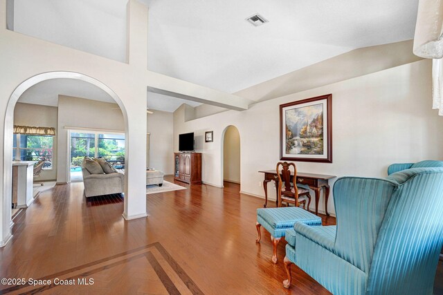 1068 Egret Lake Way, Melbourne, FL 32940 - living room with arched walkways, baseboards, and wood finished floors