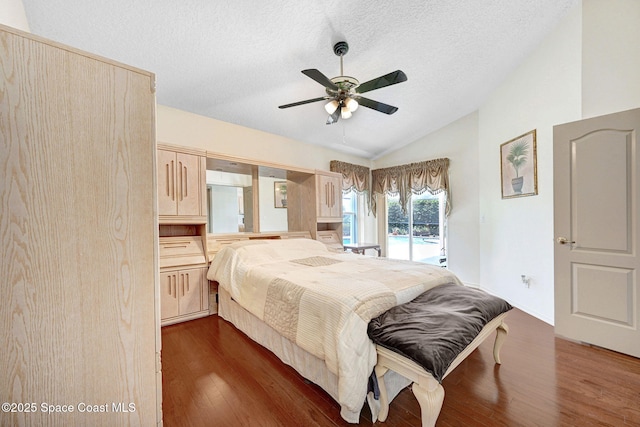 1068 Egret Lake Way, Melbourne, FL 32940 - bedroom featuring access to exterior, dark wood-style floors, vaulted ceiling, a textured ceiling, and a ceiling fan