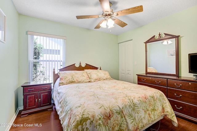 1068 Egret Lake Way, Melbourne, FL 32940 - bedroom with dark wood-style floors, a closet, a ceiling fan, and baseboards