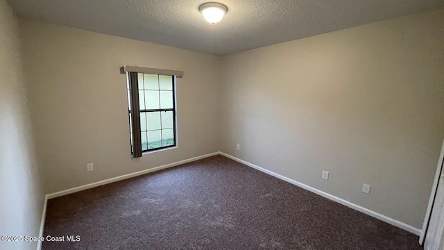975 Luminary Cir Unit 103, Melbourne, FL 32901 - empty room featuring baseboards, dark carpet, and a textured ceiling