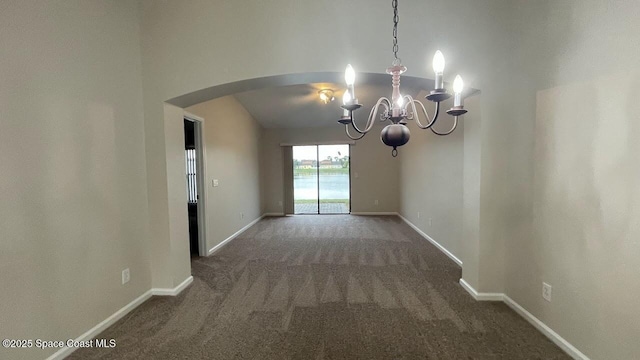 975 Luminary Cir Unit 103, Melbourne, FL 32901 - spare room featuring arched walkways, dark carpet, a chandelier, and baseboards