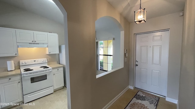 975 Luminary Cir Unit 103, Melbourne, FL 32901 - kitchen featuring arched walkways, white electric stove, under cabinet range hood, vaulted ceiling, and white cabinetry