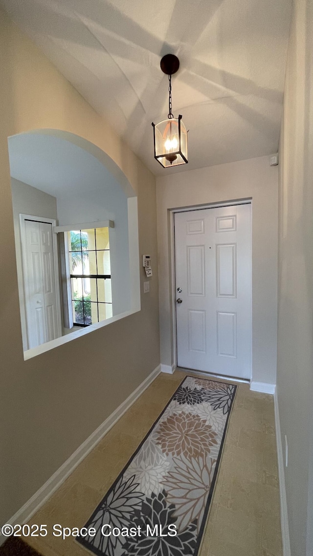 975 Luminary Cir Unit 103, Melbourne, FL 32901 - entryway with arched walkways, baseboards, a chandelier, and vaulted ceiling