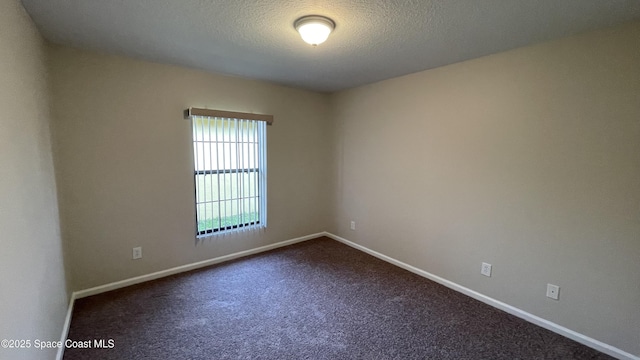 975 Luminary Cir Unit 103, Melbourne, FL 32901 - unfurnished room featuring baseboards, dark carpet, and a textured ceiling