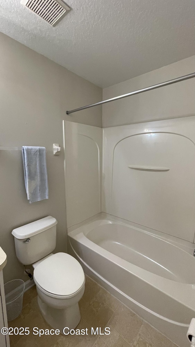 975 Luminary Cir Unit 103, Melbourne, FL 32901 - full bathroom featuring shower / tub combination, toilet, a textured ceiling, vanity, and tile patterned flooring