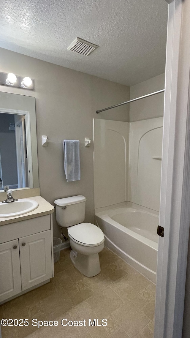 975 Luminary Cir Unit 103, Melbourne, FL 32901 - full bath featuring vanity, toilet,  shower combination, and a textured ceiling