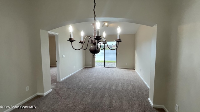 975 Luminary Cir Unit 103, Melbourne, FL 32901 - spare room with a chandelier, arched walkways, carpet flooring, and baseboards