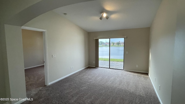 975 Luminary Cir Unit 103, Melbourne, FL 32901 - spare room featuring arched walkways, carpet flooring, and baseboards