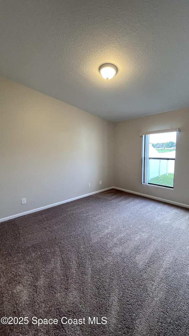 975 Luminary Cir Unit 103, Melbourne, FL 32901 - unfurnished room featuring a textured ceiling, baseboards, and carpet floors