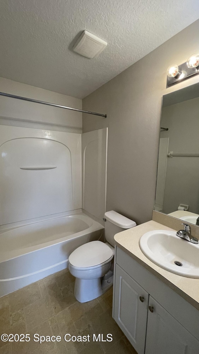 975 Luminary Cir Unit 103, Melbourne, FL 32901 - bathroom with vanity,  shower combination, toilet, and a textured ceiling