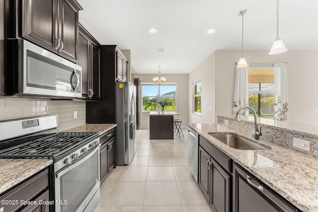 2810 Amethyst Way, Melbourne, FL 32940 - kitchen featuring appliances with stainless steel finishes, a chandelier, backsplash, light stone countertops, and decorative light fixtures