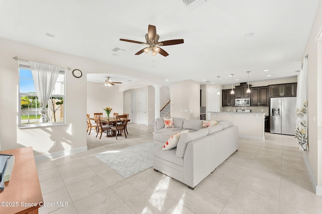 2810 Amethyst Way, Melbourne, FL 32940 - living area with ceiling fan, ornate columns, light tile patterned floors, stairs, and arched walkways