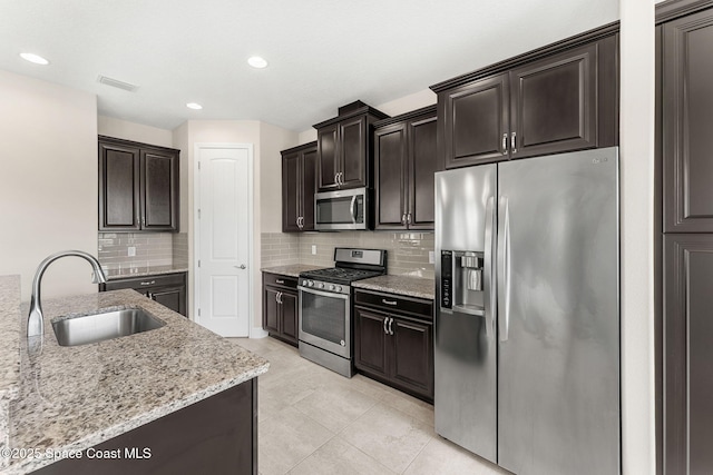 2810 Amethyst Way, Melbourne, FL 32940 - kitchen with appliances with stainless steel finishes, tasteful backsplash, light stone counters, recessed lighting, and dark brown cabinets