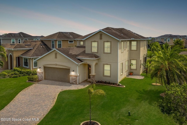 2810 Amethyst Way, Melbourne, FL 32940 - traditional-style home featuring stucco siding, decorative driveway, an attached garage, a front yard, and stone siding