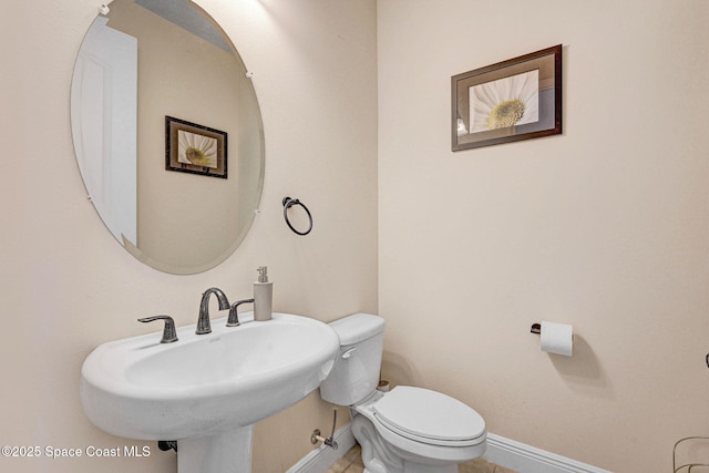 8212 Paragrass Ave, Melbourne, FL 32940 - bathroom with baseboards, toilet, a sink, and tile patterned flooring