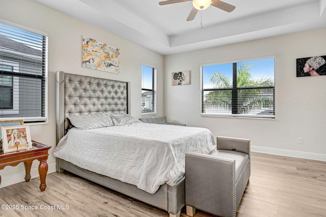 8212 Paragrass Ave, Melbourne, FL 32940 - bedroom with wood finished floors, baseboards, ceiling fan, and a tray ceiling
