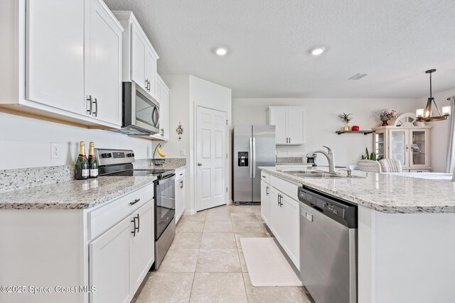 637 Old Country Rd SE, Palm Bay, FL 32909 - kitchen with stainless steel appliances, a sink, white cabinetry, a center island with sink, and recessed lighting