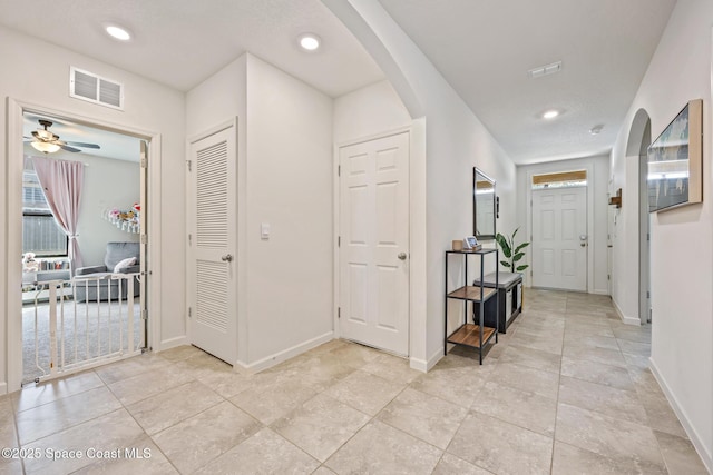637 Old Country Rd SE, Palm Bay, FL 32909 - hallway featuring arched walkways, baseboards, recessed lighting, plenty of natural light, and light tile patterned floors