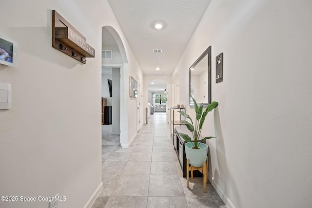 637 Old Country Rd SE, Palm Bay, FL 32909 - hallway with arched walkways, baseboards, and light tile patterned flooring