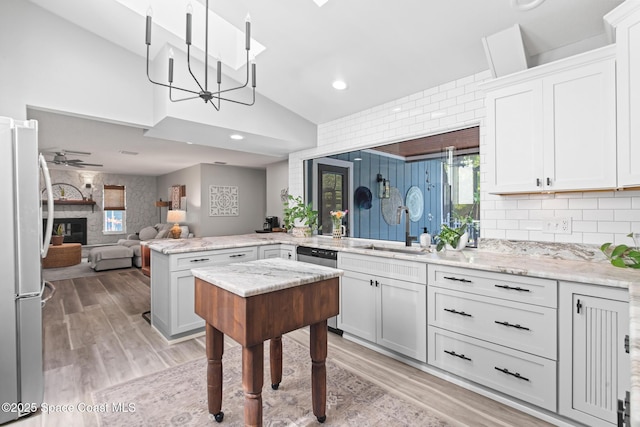 3203 Wind Song Ct, Melbourne, FL 32934 - kitchen with a sink, freestanding refrigerator, lofted ceiling, a peninsula, and healthy amount of natural light