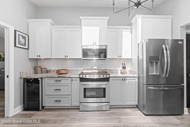 3203 Wind Song Ct, Melbourne, FL 32934 - kitchen with appliances with stainless steel finishes, wine cooler, backsplash, and light stone counters