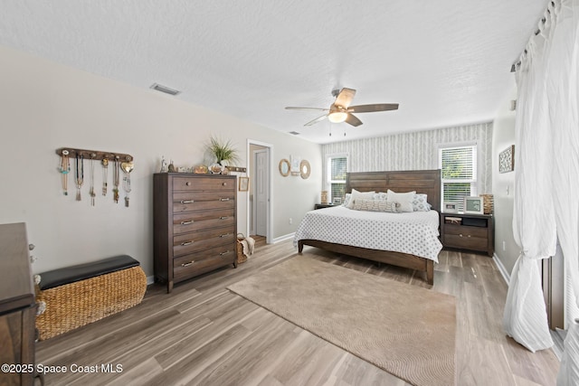 3203 Wind Song Ct, Melbourne, FL 32934 - bedroom featuring wood finished floors, baseboards, ceiling fan, and a textured ceiling