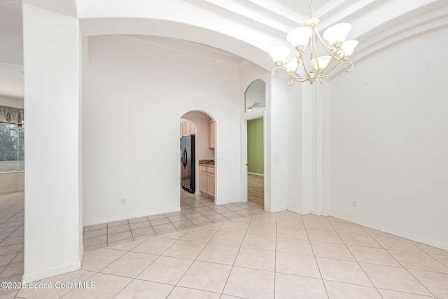 2703 Barrow Dr, Merritt Island, FL 32952 - empty room featuring arched walkways, a chandelier, and light tile patterned flooring