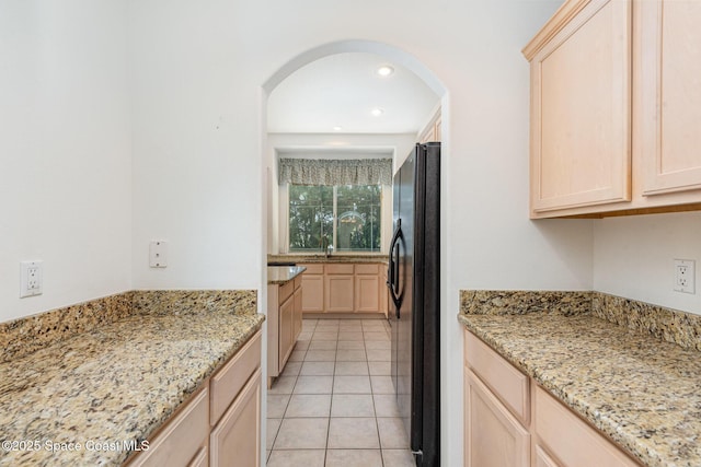 2703 Barrow Dr, Merritt Island, FL 32952 - kitchen with light brown cabinetry, freestanding refrigerator, light stone countertops, light tile patterned floors, and recessed lighting