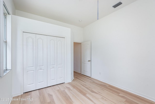 2703 Barrow Dr, Merritt Island, FL 32952 - unfurnished bedroom featuring light wood-style floors, a closet, and baseboards
