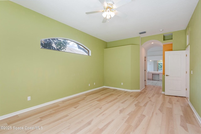 2703 Barrow Dr, Merritt Island, FL 32952 - empty room featuring arched walkways, light wood-style flooring, ceiling fan, and baseboards