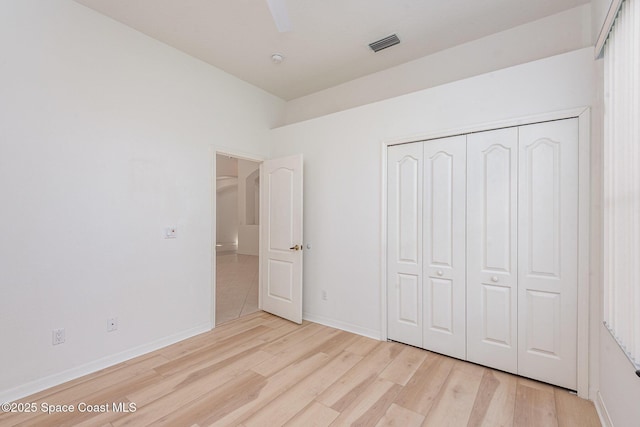 2703 Barrow Dr, Merritt Island, FL 32952 - unfurnished bedroom with light wood-style flooring, a closet, baseboards, and ceiling fan