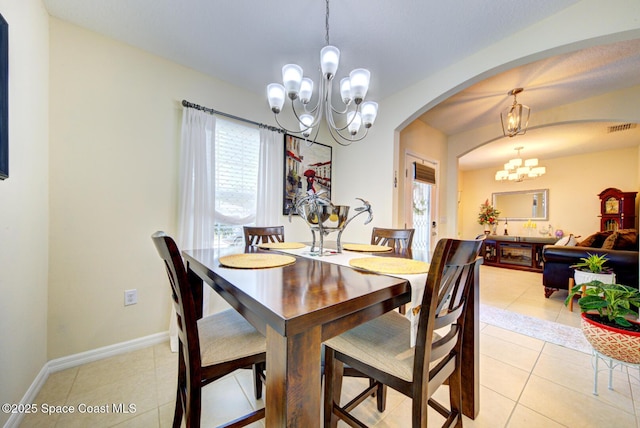469 Aviation Ave NE, Palm Bay, FL 32907 - dining room featuring a chandelier, arched walkways, healthy amount of natural light, and light tile patterned floors