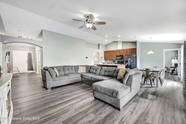 870 Buchanan Ave SE, Palm Bay, FL 32909 - living area with arched walkways, lofted ceiling, a ceiling fan, wood finished floors, and recessed lighting