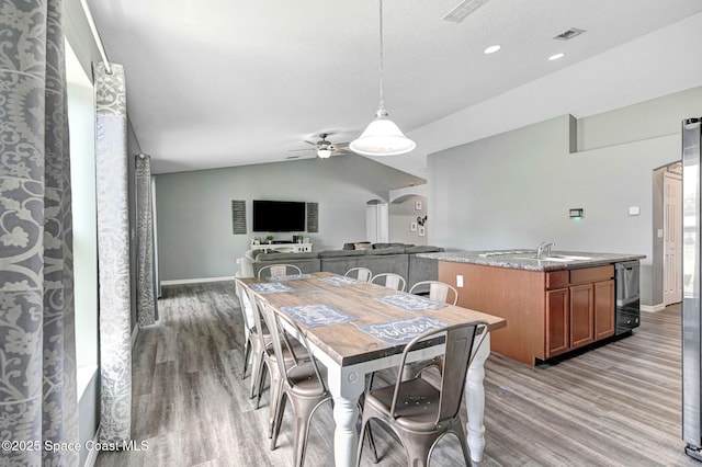870 Buchanan Ave SE, Palm Bay, FL 32909 - dining room featuring light wood-style flooring, ceiling fan, lofted ceiling, baseboards, and arched walkways