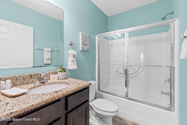 681 Dillard Dr SE, Palm Bay, FL 32909 - full bathroom featuring vanity, combined bath / shower with glass door, toilet, and wood finished floors