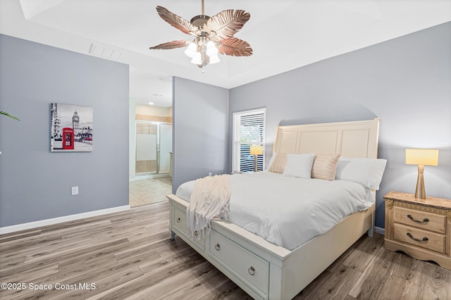681 Dillard Dr SE, Palm Bay, FL 32909 - bedroom featuring light wood-style floors, baseboards, ensuite bath, and a ceiling fan