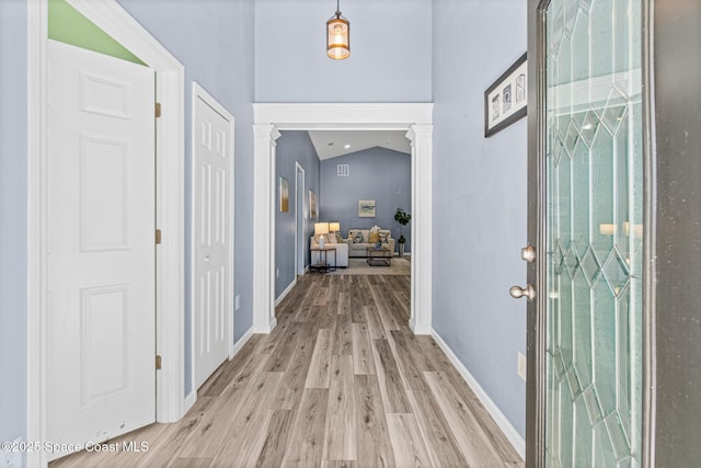 681 Dillard Dr SE, Palm Bay, FL 32909 - foyer with light wood-style floors, decorative columns, baseboards, and lofted ceiling