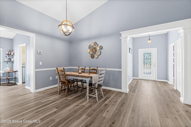 681 Dillard Dr SE, Palm Bay, FL 32909 - dining room featuring wood finished floors, a chandelier, vaulted ceiling, and baseboards