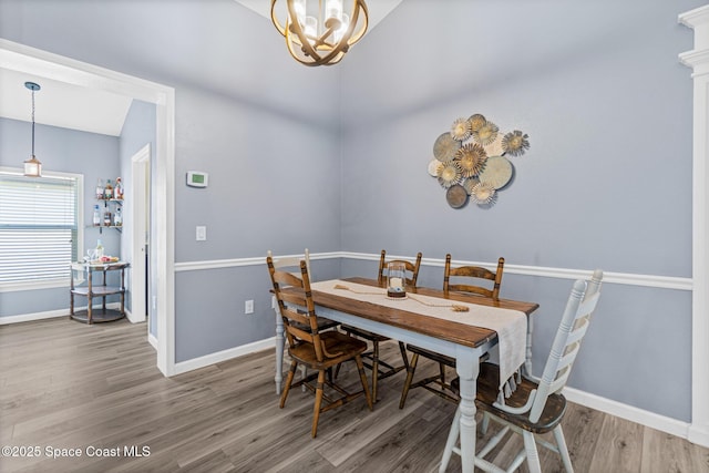 681 Dillard Dr SE, Palm Bay, FL 32909 - dining area with wood finished floors, baseboards, and a chandelier