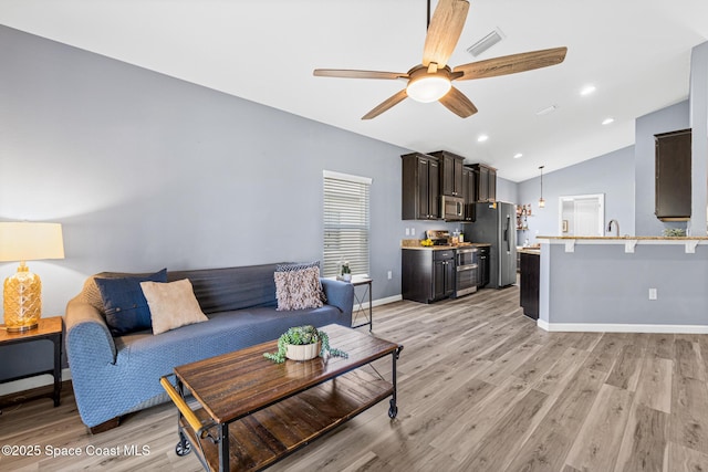 681 Dillard Dr SE, Palm Bay, FL 32909 - living room with light wood-style flooring, vaulted ceiling, ceiling fan, baseboards, and recessed lighting