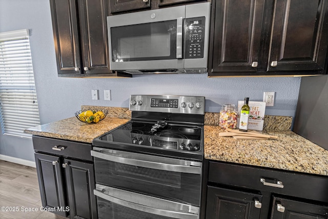 681 Dillard Dr SE, Palm Bay, FL 32909 - kitchen with stainless steel appliances, baseboards, light stone countertops, and dark brown cabinetry
