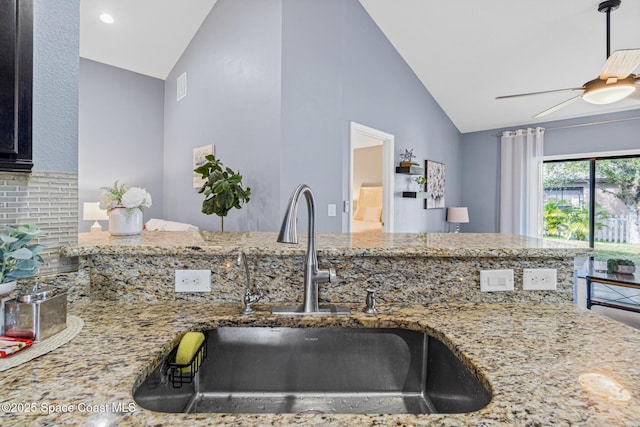 681 Dillard Dr SE, Palm Bay, FL 32909 - kitchen with a sink, light stone counters, ceiling fan, and high vaulted ceiling