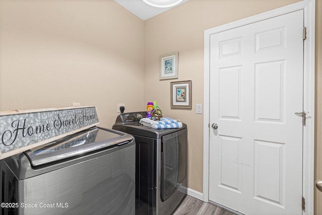 681 Dillard Dr SE, Palm Bay, FL 32909 - laundry room featuring washing machine and clothes dryer, wood finished floors, and baseboards